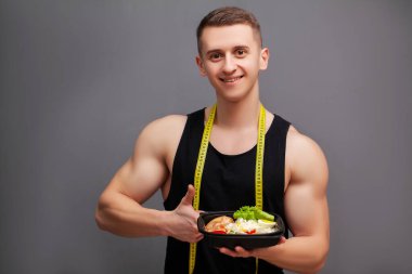 Spor beslenmesi için protein zengini yiyeceklerle dolu bir kutu tutan adam.