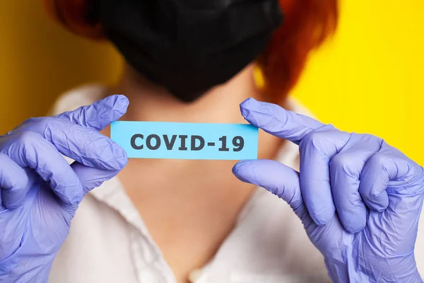 Mujer con guantes protectores con inscripción coronavirus —  Fotos de Stock