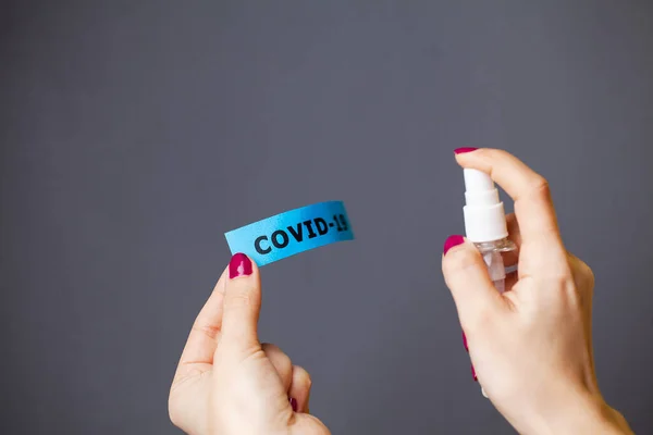 Primer plano de la mujer rociando antiséptico en la inscripción coronavirus —  Fotos de Stock