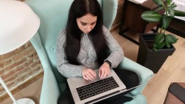 Genç bir kadın evde kalıyor ve virüs salgını sırasında internette çalışıyor.