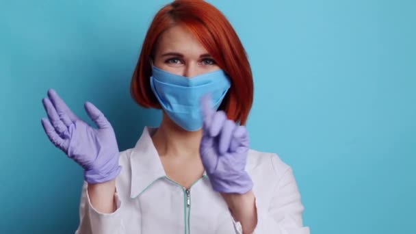 Junge Krankenschwester zeigt auf Video, wie man persönliche Schutzausrüstung sicher entfernt — Stockvideo