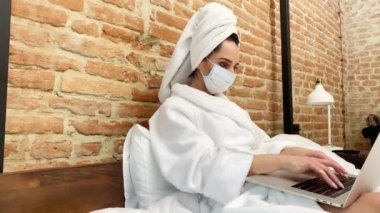 Genç bir kadın evde kalıyor ve virüs salgını sırasında internette çalışıyor.
