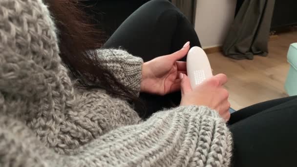 Jonge vrouw blijft thuis en meet de temperatuur met een elektronische thermometer — Stockvideo