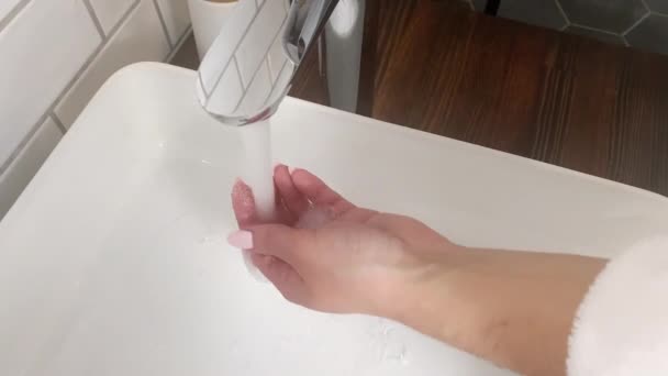 Молодая женщина моет руки с мылом в ванной — стоковое видео