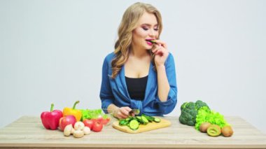 Sıkı diyette olan genç bir kadın taze sebze salatası hazırlıyor.