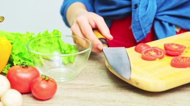 Young woman on a strict diet prepares a salad of fresh vegetables — Stock Video