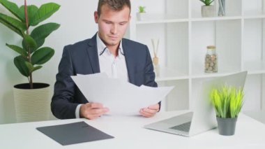 Ofisteki belgelerle çalışan genç adam.