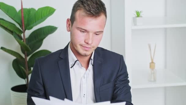 Young man working with documents in office at desk — Stock Video
