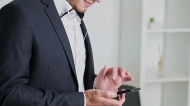 Genç adam şirket ofisinde telefonla satıyor.
