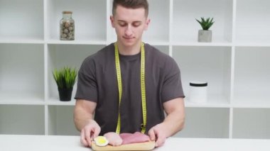 Genç sporcu elinde yüksek proteinli bir yemek tutuyor.