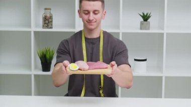 Genç sporcu elinde yüksek proteinli bir yemek tutuyor.