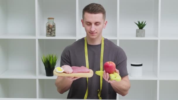 Joven deportista sosteniendo una comida rica en proteínas en sus manos — Vídeo de stock