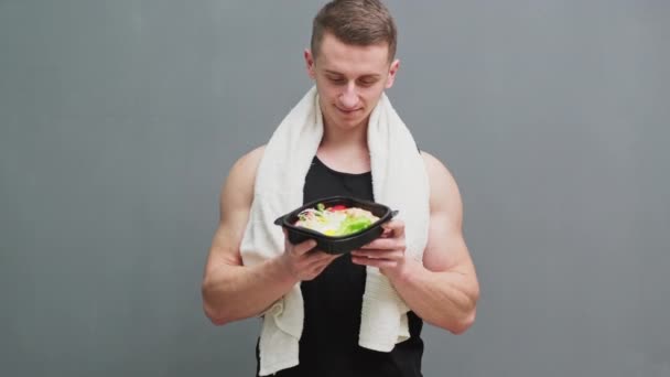 Mladý sportovní muž drží v rukou jídlo s vysokým obsahem bílkovin — Stock video