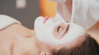 Genç güzellik salonunu ziyaret eder ve yüz bakımı için maske taktırır.
