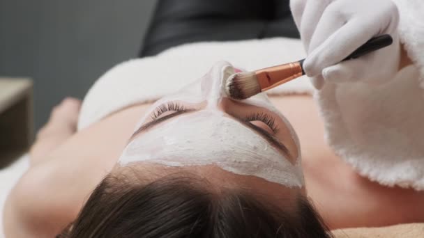 Jonge schoonheid bezoekt spa salon en ontvang gezichtsmasker voor gezichtsverzorging — Stockvideo