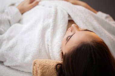 Kaplıca salonunda kozmetik hizmeti alan genç bir kadın.