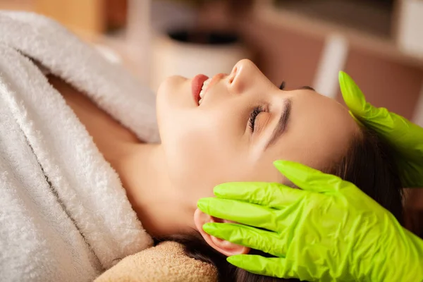 Young woman receiving cosmetic services in spa salon