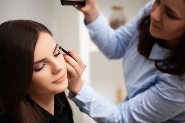 Maquiagem artista faz maquiagem profissional para o cliente em sua casa — Fotografia de Stock