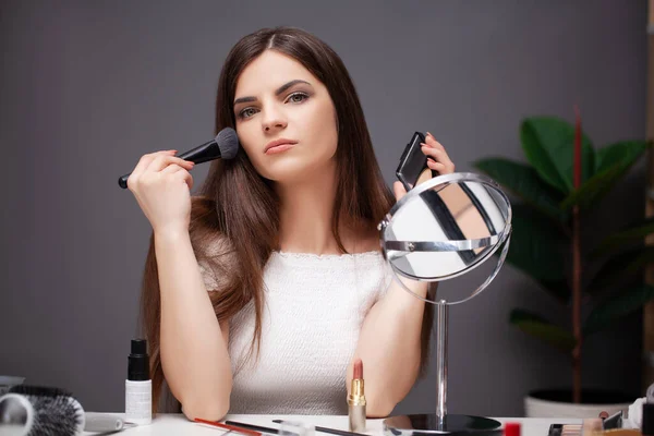 Hübsche Frau schminkt sich zu Hause vor dem Spiegel — Stockfoto