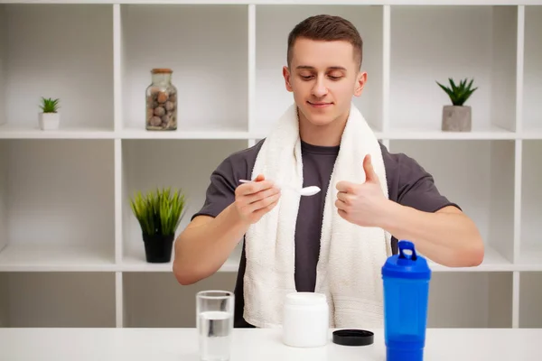 Man prepares a protein shake in the shaker after training.