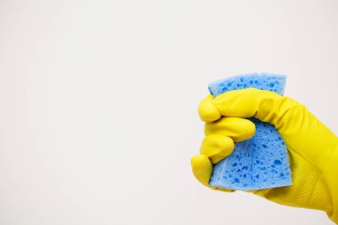 Sarı eldivenli el sıkışın ve temizlik malzemelerini tutun..