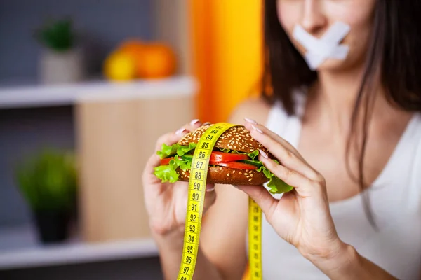Kvinna äter skadlig mat som bidrar till övervikt. — Stockfoto