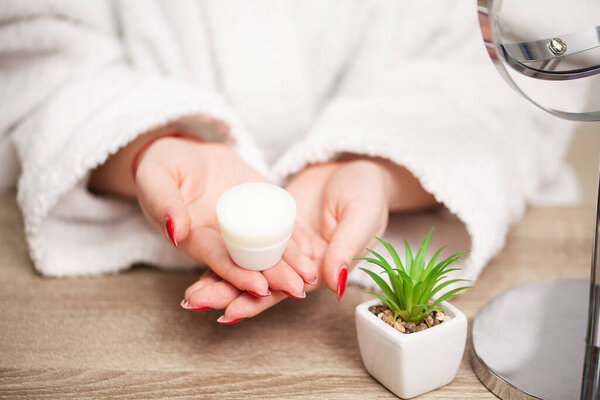 Крупный план девушка кладет крем для лица на руку
.