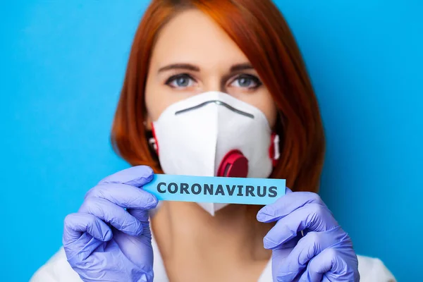 Mulher em luvas de proteção segurando inscrição coronavírus . — Fotografia de Stock