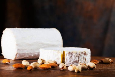 Tahta bir tahtanın üzerinde dilimlenmiş elit çeşitlilikteki peynirler