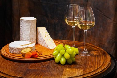 Tahta bir tahtanın üzerinde dilimlenmiş elit çeşitlilikteki peynirler