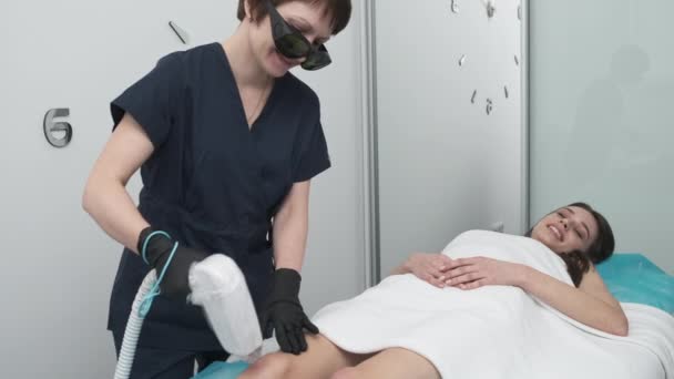 Mulher bonita em um salão de beleza recebe um procedimento de depilação a laser — Vídeo de Stock