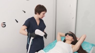 Güzellik salonunda güzel bir kadın lazer tüy temizleme ameliyatı olur.