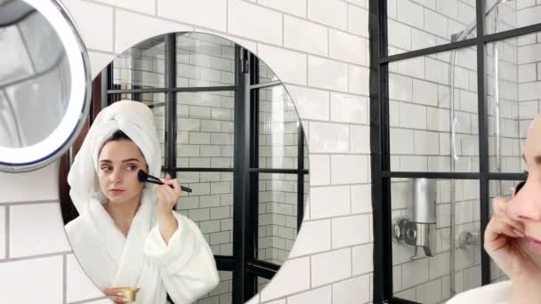 Bella donna che fa il trucco in bagno vicino specchio — Video Stock