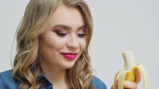 Comida saludable en casa, mujer en la cocina comiendo un plátano maduro — Vídeos de Stock