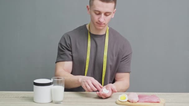 Mann hält Pillen als Nahrungsergänzung zur Sporternährung in der Hand — Stockvideo