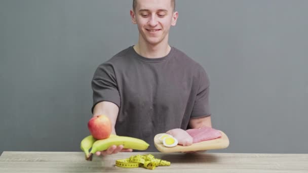 Konzept der gesunden Ernährung, ein Mann, der frisches Fleisch mit viel Protein hält — Stockvideo