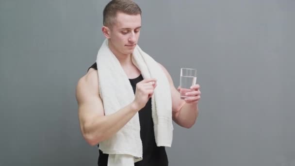 Mann hält Pillen als Nahrungsergänzung zur Sporternährung in der Hand — Stockvideo