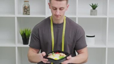 Sağlıklı beslenme kavramı, atletik yapılı bir adam kilo vermek için düzgün yemek yer.