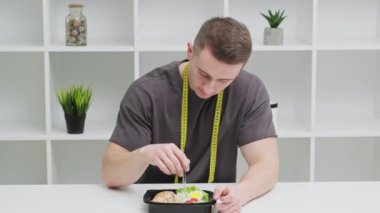 Sağlıklı beslenme kavramı, atletik yapılı bir adam kilo vermek için düzgün yemek yer.