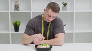 Sağlıklı beslenme kavramı, atletik yapılı bir adam kilo vermek için düzgün yemek yer.