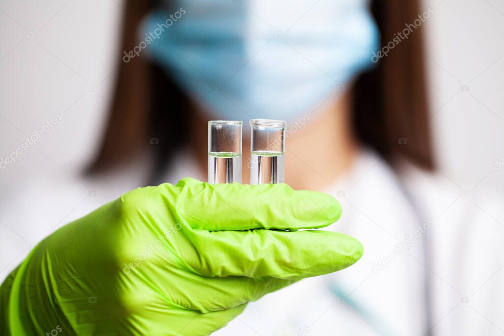 Close-up of a doctor holding test tubes with vaccine