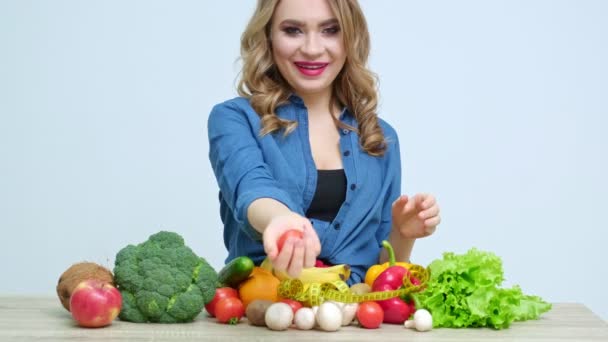 Όμορφη γυναίκα στην κουζίνα κρατώντας μια ντομάτα — Αρχείο Βίντεο