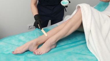 Güzellik stüdyosunda lazer tüy çıkarma prosedürü uygulayan güzel bir kız.