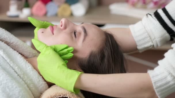 Donna sotto massaggio facciale professionale in beauty spa — Video Stock