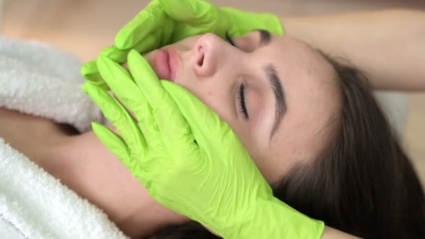 Женщина под профессиональным массажем лица в салоне красоты — стоковое видео