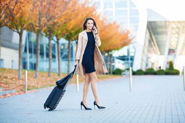 Mulher perto do aeroporto com uma mala está indo em uma viagem — Fotografia de Stock