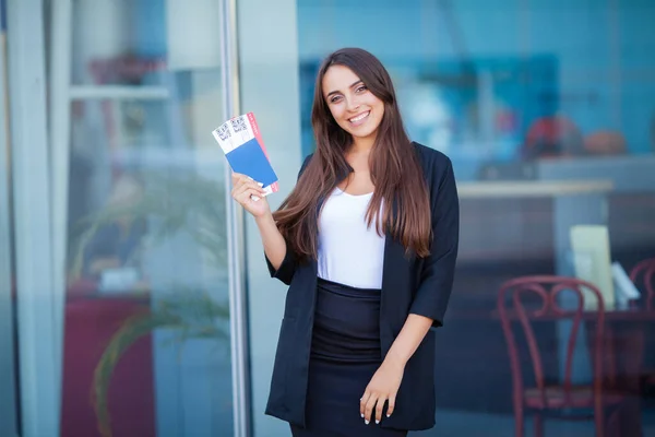 Vrouw bij de luchthaven met een paspoort en vliegtickets — Stockfoto