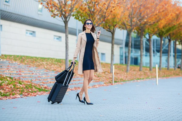 Γυναίκα κοντά στο αεροδρόμιο με μια βαλίτσα πρόκειται για ένα ταξίδι — Φωτογραφία Αρχείου