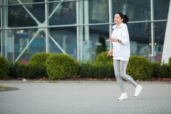 Mooie vrouw doet fitness buiten luisteren naar muziek — Stockfoto