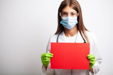 Eldivenli, maskeli ve gözlüklü doktor mesaj için boş bir form tutuyor.